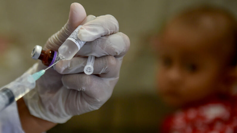 Un trabajador médico se prepara para administrar la vacuna contra la poliomielitis a un bebé en un puesto de servicio en Banda Aceh el 4 de noviembre de 2020. (Chaideer Mahyuddin/ AFP a través de Getty Images)