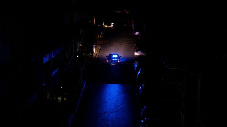 Un coche de policía patrulla una calle oscura en San Juan, Puerto Rico, el 10 de junio de 2021. (RICARDO ARDUENGO/AFP vía Getty Images)