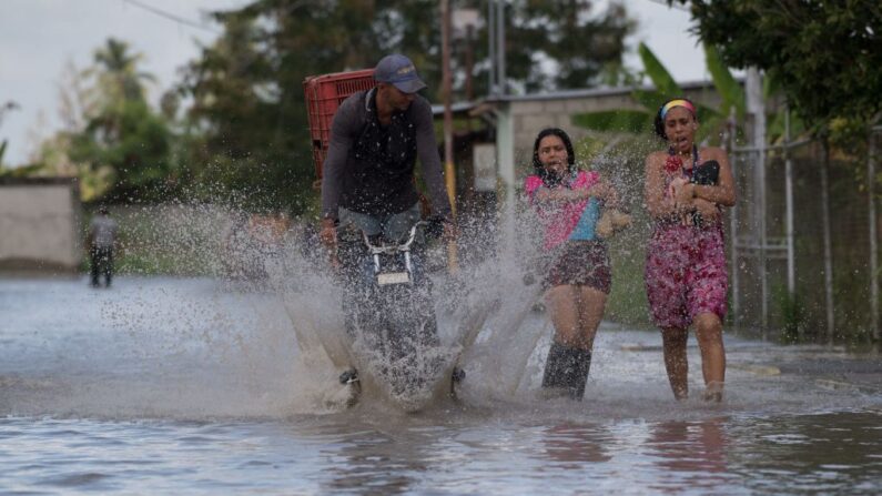 En una fotografía de archivo, un hombre conduce una motocicleta en una calle inundada de la ciudad de La Fortuna en el estado de Zulia, Venezuela, el 10 de septiembre de 2021. (Federico Parra/AFP vía Getty Images)