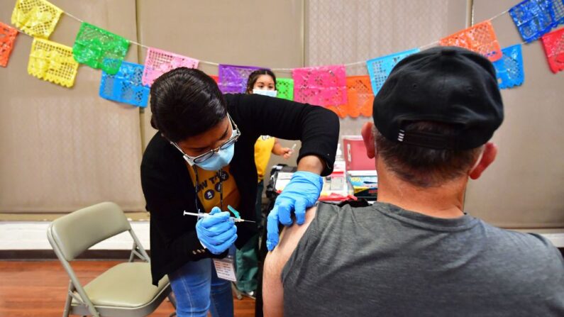 La enfermera titulada Mariam Salaam administra la vacuna de refuerzo de Pfizer en un centro de vacunación y pruebas de Covid decorado para el Cinco de Mayo en el parque Ted Watkins de Los Ángeles el 5 de mayo de 2022. (FREDERIC J. BROWN/AFP vía Getty Images)
