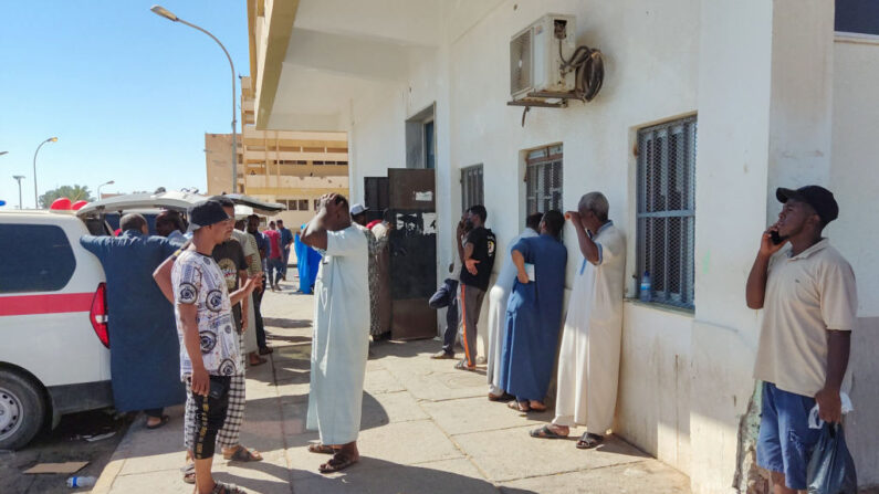 Los familiares de los heridos en la explosión de un camión cisterna esperan frente al hospital al que fueron trasladados en la ciudad de Sebha, en el sur de Libia, el 1 de agosto de 2022. (ABDELMONEIM AL-JAHIMI/AFP vía Getty Images)