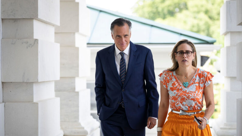 El senador Mitt Romney (R-UT) y la senadora Kyrsten Sinema (D-AZ) caminan juntos fuera del Capitolio de los Estados Unidos el 4 de agosto de 2022 en Washington, DC. mientras siguen las negociaciones sobre el acuerdo de reconciliación del presupuesto del Senado, que los demócratas del Senado han denominado Ley de Reducción de la Inflación de 2022. (Drew Angerer/Getty Images)