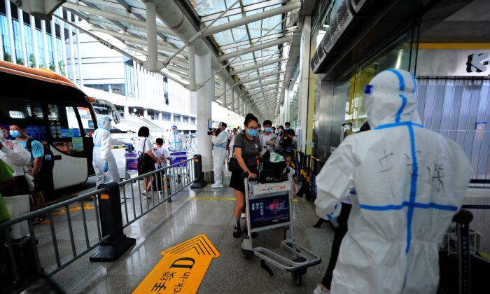 Turistas pasan por sus trámites de check-in en el aeropuerto de Sanya Phoenix para abandonar la ciudad turística de Sanya, en la isla de Hainan, China, afectada por COVID, el 9 de agosto de 2022. (STR/AFP vía Getty Images)