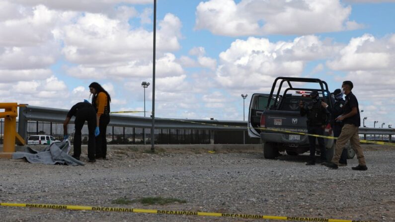 Expertos forenses inspeccionan el cuerpo de una niña migrante guatemalteca que se ahogó mientras intentaba cruzar con su madre el Río Bravo, o Río Grande, hacia los Estados Unidos, en Ciudad Juárez, estado de Chihuahua, México, el 22 de agosto de 2022. (Herika Martinez/AFP vía Getty Images)