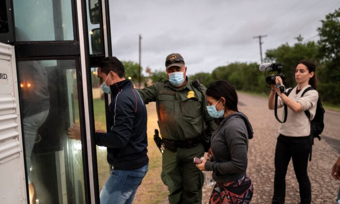 Migrantes ilegales abordan un autobús luego de ser detenidos cerca de la frontera entre México y Estados Unidos, en Del Rio, Texas, el 16 de mayo de 2021. (Sergio Flores/AFP vía Getty Images)
