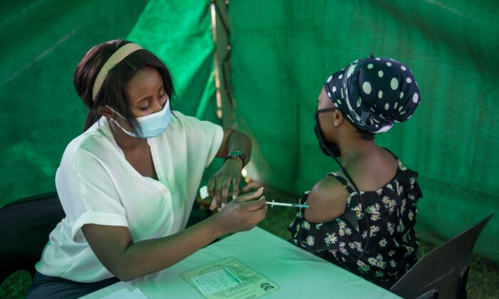 Un trabajador sanitario administra la vacuna COVID-19 de Johnson & Johnson a una mujer a la salida de un colegio electoral en el Kopanong Hall de Soweto, Sudáfrica, el 1 de noviembre de 2021. (Michele Spatari/AFP vía Getty Images)