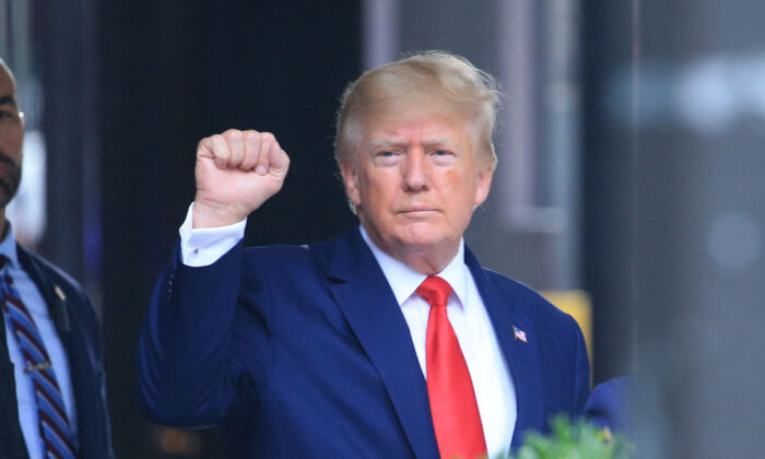 El expresidente Donald Trump levanta el puño mientras camina hacia un vehículo fuera de la Torre Trump, en Nueva York, el 10 de agosto de 2022. (Stringer/AFP vía Getty Images)