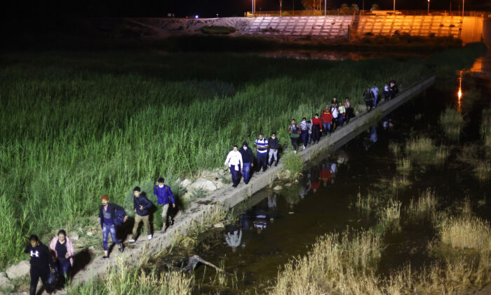 Inmigrantes ilegales caminan desde México hacia Estados Unidos a la espera de ser procesados por la Patrulla Fronteriza de Estados Unidos en Yuma, Arizona, el 23 de mayo de 2022. (Mario Tama/Getty Images)