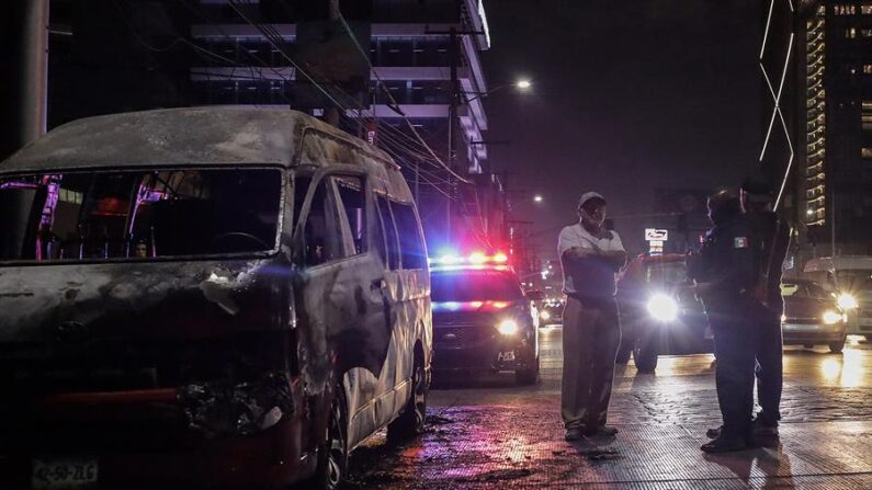Agentes de policía prestan guardia en la zona donde fue incendiado un vehículo, el 12 de agosto de 2022, en la ciudad de Tijuana, estado de Baja California, México. (EFE/ Joebeth Terriquez)