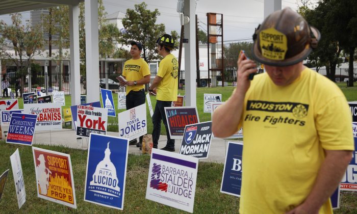 Los bomberos animan fuera del centro de votación del Metropolitan Multi-Service Center el 6 de noviembre de 2018 en Houston, Texas, a los votantes a votar sobre una proposición que aumentaría su salario. (Loren Elliott/Getty Images)