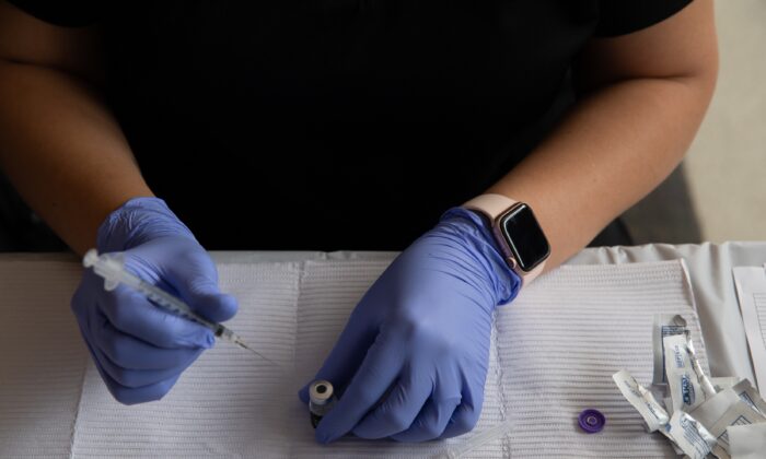 Un trabajador sanitario prepara una vacuna contra COVID-19 en Southfield, Michigan, en una imagen de archivo del 24 de agosto de 2021. (Emily Elconin/Getty Images)