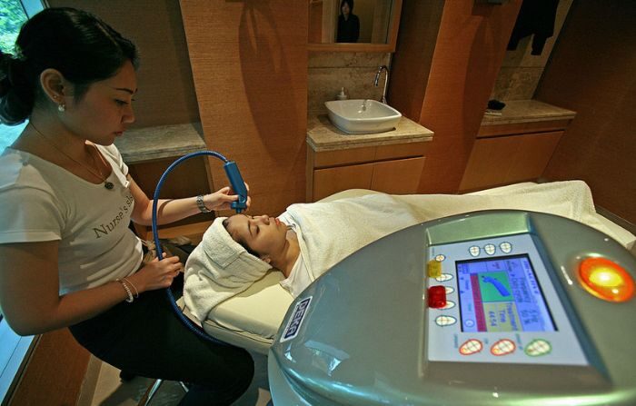 Una terapeuta aplica un tratamiento facial de estimulación profunda con láser a una clienta. (SAEED KHAN/AFP vía Getty Images)