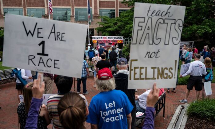 La gente sostiene carteles durante una manifestación contra la "Teoría Crítica de la Raza" (TCR) que se enseña en las escuelas del centro gubernamental del condado de Loudoun, en Leesburg, Virginia, el 12 de junio de 2021. (Andrew Caballero-Reynolds/AFP vía Getty Images)
