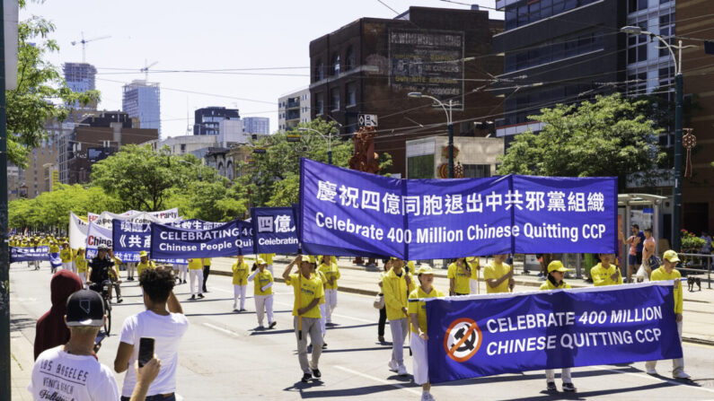 Los residentes observan cómo cientos de personas marchan en un desfile para celebrar que 400 millones de chinos abandonaron el Partido Comunista Chino y sus organizaciones afiliadas, en el centro de Toronto el 6 de agosto de 2022. (Evan Ning/The Epoch Times)
