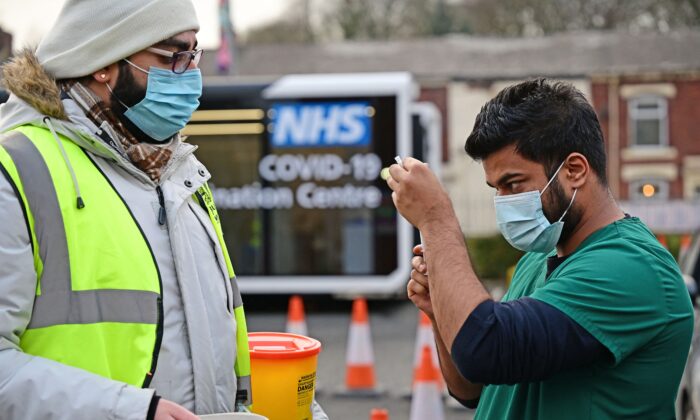 Un trabajador del servicio de salud extrae una dosis de la vacuna COVID-19 en un centro de vacunación en Blackburn, Inglaterra, el 17 de enero de 2022. (Paul Ellis/AFP a través de Getty Images)