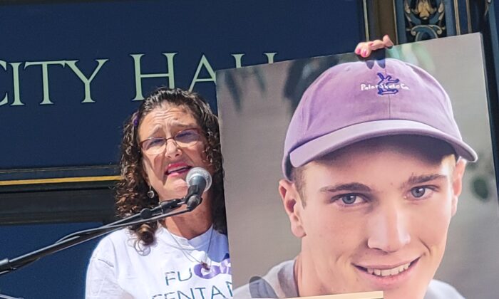 Michelle Leopold habla en un mitin frente al Ayuntamiento de San Francisco el 21 de agosto de 2022, mientras sostiene una foto de su hijo Trevor, que fue víctima de envenenamiento con fentanilo. (Jason Blair/NTD)