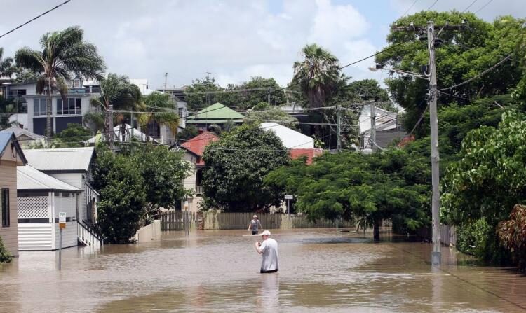 Los residentes desafían las aguas de las inundaciones provocadas por el ciclo meteorológico de La Niña en Brisbane, Australia, el 12 de enero de 2011. (Bradley Kanaris/Getty Images)
