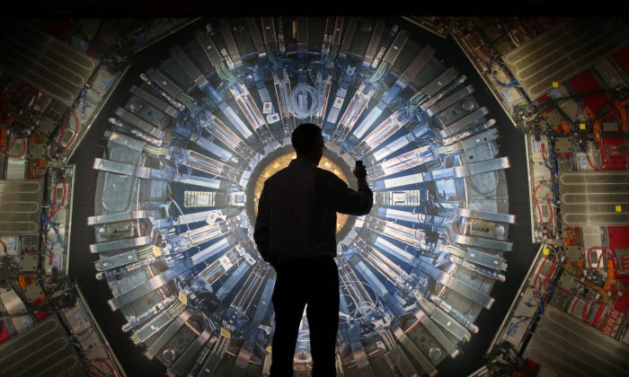 Un visitante toma una fotografía con su teléfono a una gran imagen retroiluminada del Gran Colisionador de Hadrones (LHC), en la exhibición "Colisionador" del Museo de Ciencias en Londres, el 12 de noviembre de 2013. (Peter Macdiarmid/Getty Images)
