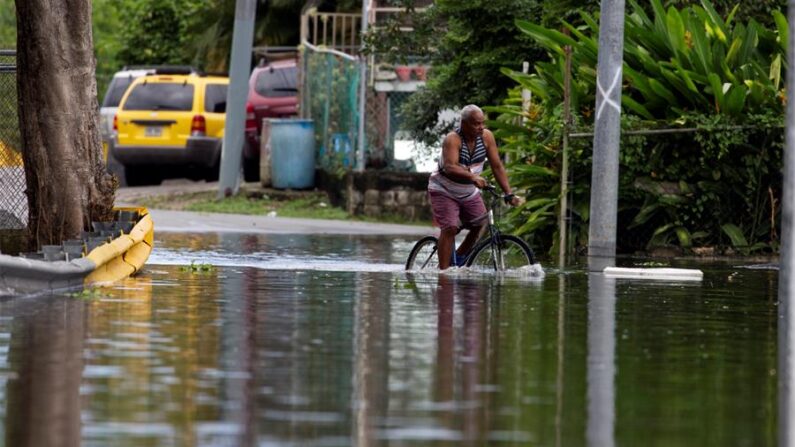 Fotografía de archivo de un hombre que cruza en bicicleta una calle inundada debido a las intensas lluvias registradas en Cataño (Puerto Rico). EFE/ Thais Llorca