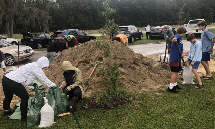 A medida que las primeras lluvias del huracán Ian comienzan a caer en el centro norte de Florida, los residentes del condado de Alachua llenan sacos de arena en estaciones de bricolaje con palas traídas de casa, el 28 de septiembre de 2022. (Nanette Holt/The Epoch Times)
