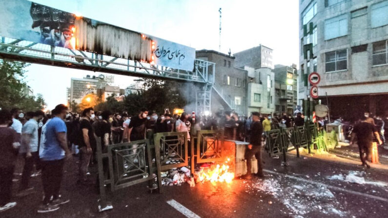 Una imagen obtenida por AFP en el exterior de Irán, el 21 de septiembre de 2022, muestra a manifestantes iraníes quemando un cubo de basura en la capital, Teherán, durante una protesta por Mahsa Amini, días después de su muerte bajo custodia policial. (AFP vía Getty Images)