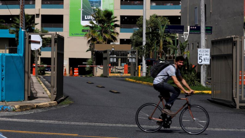 Un hombre pasa en bicicleta frente a las oficinas de Luma Energy, en el barrio de Santurce en San Juan (Puerto Rico). Imagen de archivo. EFE/Thais LLorca