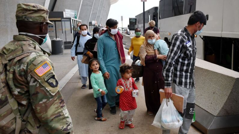 Refugiados afganos suben a un autobús tras llegar al aeropuerto internacional de Dulles, el 27 de agosto de 2021, en Dulles, Virginia. (OLIVIER DOULIERY/AFP a través de Getty Images)