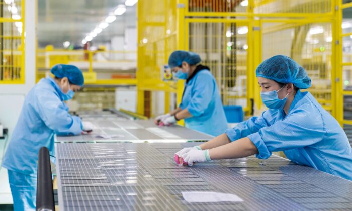 Unos trabajadores fabrican módulos solares fotovoltaicos utilizados para pequeños paneles solares en una fábrica de Haian, en la provincia oriental china de Jiangsu, el 7 de enero de 2022. (STR/AFP vía Getty Images)