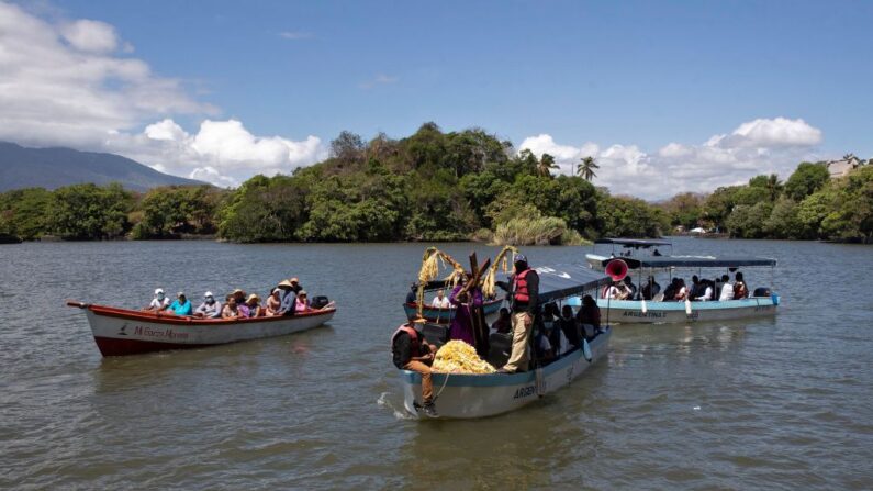 Fieles católicos llegan a una de las estaciones de la pasión de Jesucristo durante el Vía Crucis que se realiza en el Lago Cocibolca, o Lago de Nicaragua, en Granada, Nicaragua, el 11 de abril de 2022. (Oswaldo Rivas/AFP vía Getty Images)