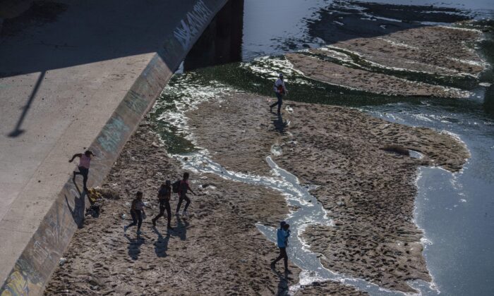 Los migrantes aparecen cruzando la frontera hacia El Paso, Texas, en una visto desde Ciudad Juárez, estado de Chihuahua, México, el 19 de mayo de 2022. (Paul Ratje/AFP vía Getty Images)