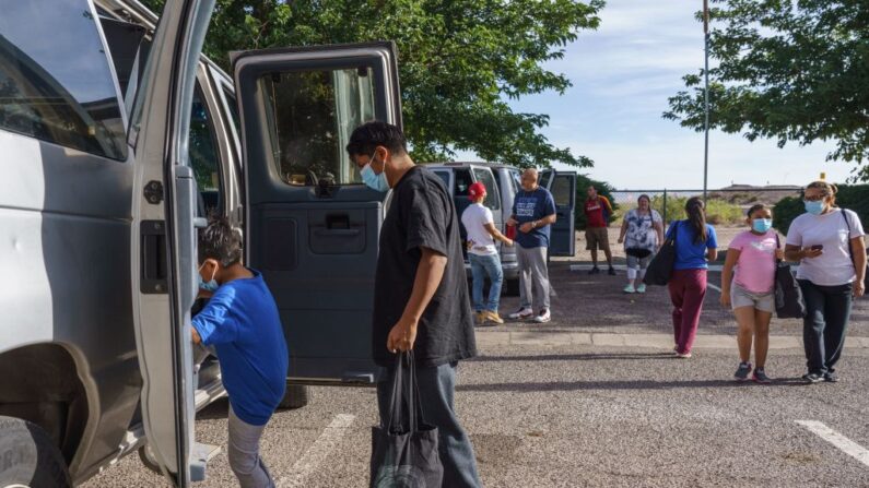 Familias suben a furgonetas para partir hacia el Aeropuerto Internacional de El Paso, donde volarán a sus destinos finales, en un motel utilizado como refugio temporal por la organización sin ánimo de lucro Colores United en Deming, Nuevo México, el 5 de junio de 2022. (PAUL RATJE/AFP vía Getty Images)
