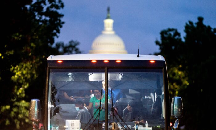 Inmigrantes ilegales, que abordaron un autobús en Texas, son dejados a la vista del edificio del Capitolio de EE.UU., en Washington, el 11 de agosto de 2022. (Stefani Reynolds/AFP a través de Getty Images)
