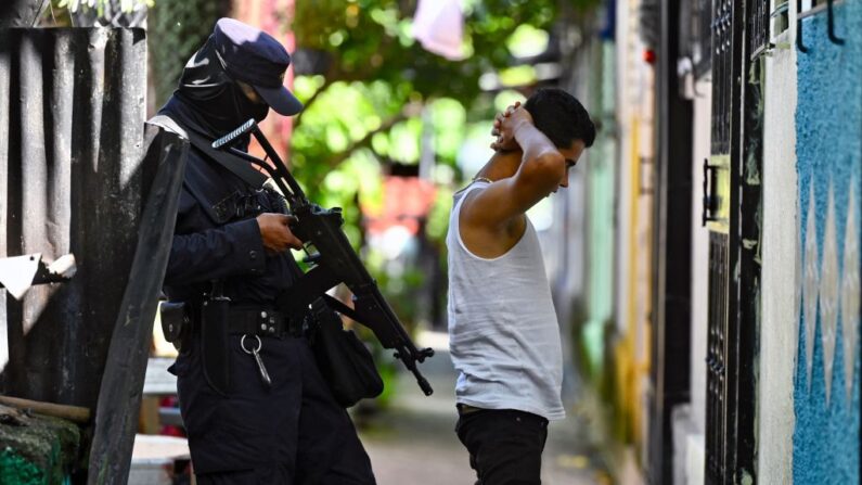 Un policía interroga a un joven durante una operación de seguridad contra la violencia de las pandillas en Soyapango, al este de la capital San Salvador, el 16 de agosto de 2022. (STHANLY ESTRADA/AFP vía Getty Images)