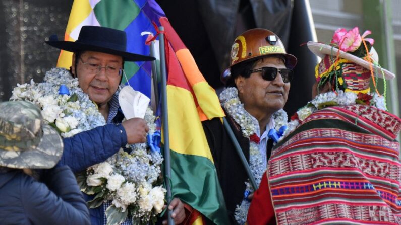 El presidente boliviano Luis Arce (I) y el ex presidente Evo Morales saludan a los indígenas durante una manifestación de apoyo al gobierno en la plaza de San Francisco en La Paz, el 25 de agosto de 2022. (AIZAR RALDES/AFP vía Getty Images)