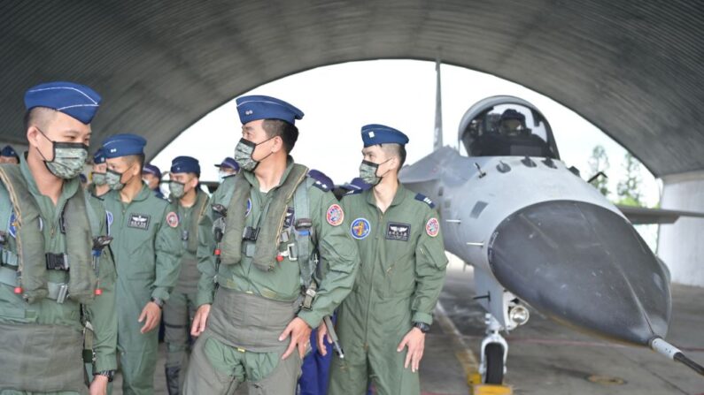 Pilotos taiwaneses pasan por delante de un caza de defensa autóctono (IDF) en una base aérea mientras la presidenta de Taiwán, Tsai Ing-wen (no en la foto), inspecciona las tropas militares en las islas Penghu el 30 de agosto de 2022. (SAM YEH/AFP vía Getty Images)
