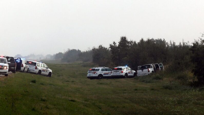 Vehículos de la Real Policía Montada de Canadá son vistos junto a una camioneta en la escena donde el sospechoso Myles Sanderson fue detenido, a lo largo de la carretera 11 cerca de la ciudad de Rosthern, Saskatchewan, Canadá, el 7 de septiembre de 2022. (LARS HAGBERG/AFP vía Getty Images)