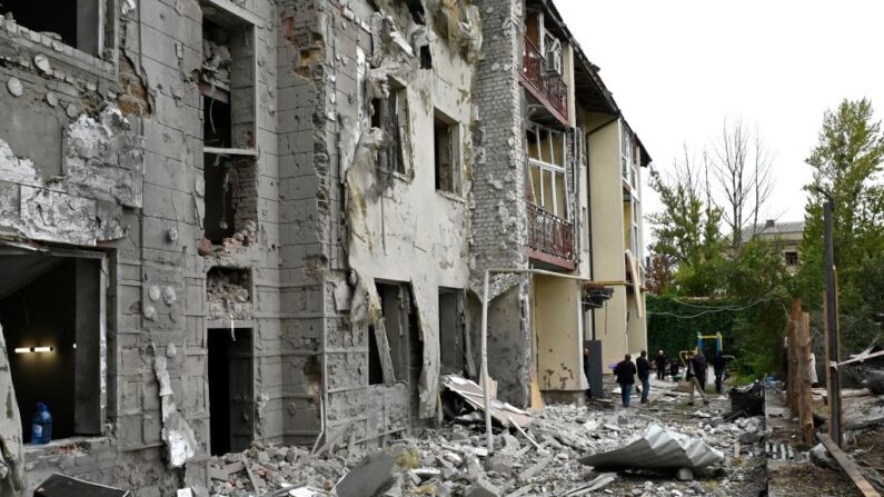 Residentes locales permanecen frente a su edificio parcialmente destruido por un ataque con misiles en Kharkiv el 12 de septiembre de 2022 en medio de la invasión rusa de Ucrania. (Sergey Bobok/AFP vía Getty Images)