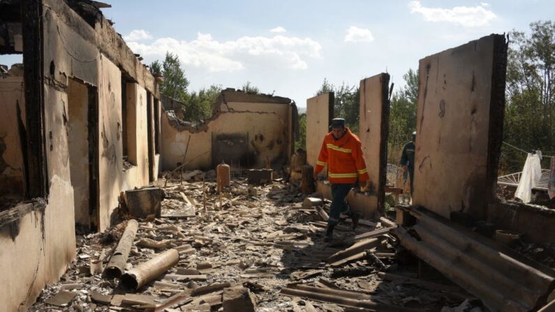 Los bomberos trabajan entre las ruinas de una casa, que se dice fue alcanzada por los bombardeos azeríes durante los recientes enfrentamientos fronterizos con Azerbaiyán, en el asentamiento de Sotk, Armenia, el 14 de septiembre de 2022. (Karen Minasyan/AFP vía Getty Images)
