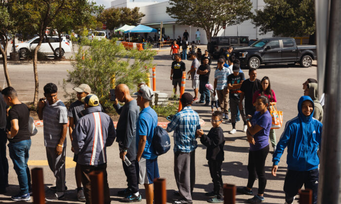 Grupos de inmigrantes ilegales en busca de asilo esperan fuera del Centro de Recursos para Migrantes para recibir comida de las Caridades Católicas de San Antonio en San Antonio, Texas, el 19 de septiembre de 2022. (Jordan Vonderhaar/Getty Images)