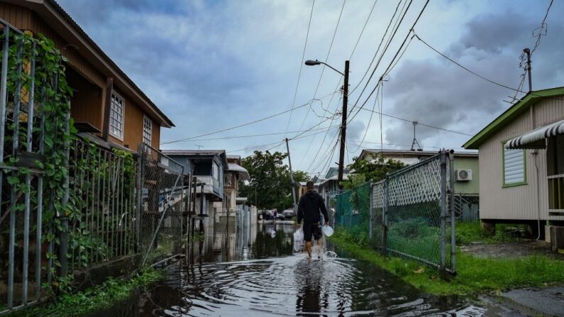 Un hombre camina por una calle inundada en el barrio Juana Matos de Catano, Puerto Rico, el 19 de septiembre de 2022, tras el paso del huracán Fiona. (AFP vía Getty Images)