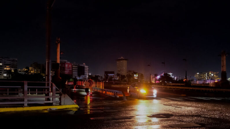 Peatones utilizan linternas mientras caminan por una calle sin luz en la comunidad Condado de Santurce en San Juan, Puerto Rico, el 19 de septiembre de 2022, tras el paso del huracán Fiona. (AFP vía Getty Images)