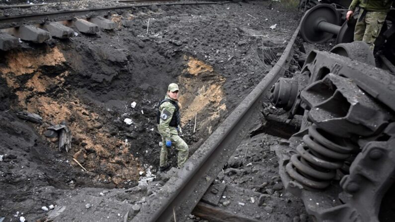 Un experto forense en explosivos examina un cráter de la explosión de un misil en una estación de ferrocarril de carga en Kharkiv, Ucrania, el 21 de septiembre de 2022, en medio de la invasión militar rusa del país. (Sergey Bobok/AFP vía Getty Images)
