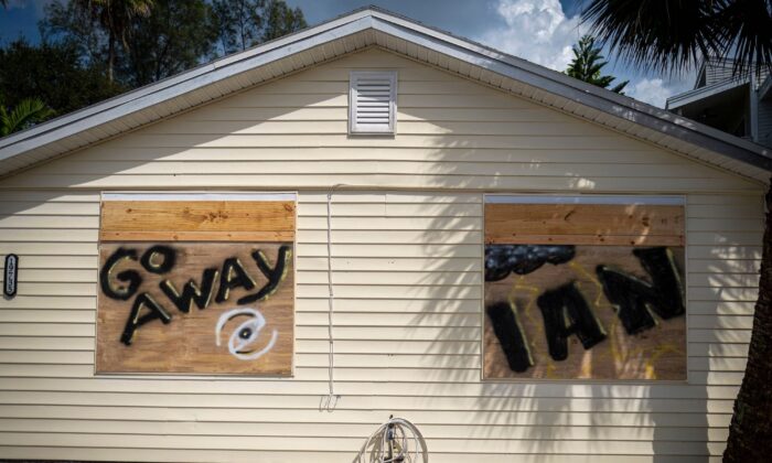 Una casa con el letrero "Go Away Ian" (Fuera Ian) pintado en las ventanas tapiadas se ve antes de la llegada del previsto huracán Ian en Indian Shores, 25 millas al oeste de Tampa, Florida, el 26 de septiembre de 2022. (Ricardo Arduengo/AFP vía Getty Images)