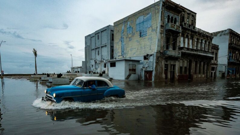 Un viejo coche americano pasa por una calle inundada en La Habana, Cuba, el 28 de septiembre de 2022, tras el paso del huracán Ian. (Yamil Lage/AFP vía Getty Images)