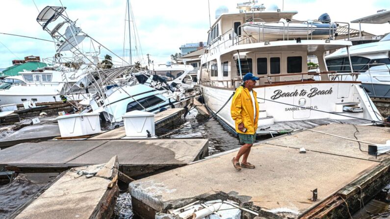 Un hombre inspecciona los daños en un puerto deportivo mientras los barcos están parcialmente sumergidos tras el paso del huracán Ian en Fort Myers, Florida, el 29 de septiembre de 2022. (Giorgio Viera/AFP vía Getty Images)
