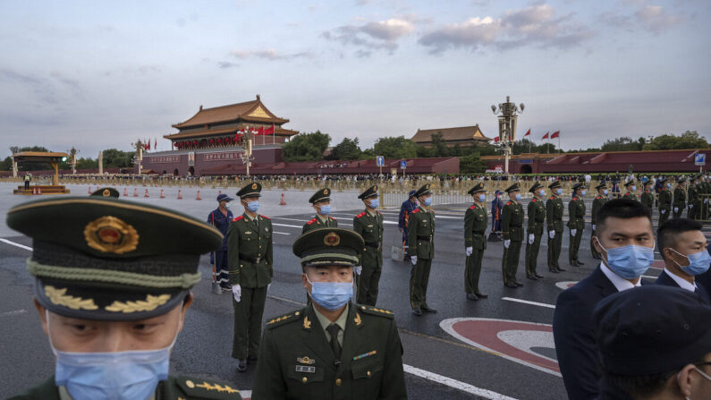 Agentes de policía y seguridad realizan el control de multitudes después de una ceremonia oficial de izado de bandera para celebrar el Día Nacional junto a la Plaza de Tiananmen y la Ciudad Prohibida en Beijing, China, el 1 de octubre de 2021. (Kevin Frayer/Getty Images)
