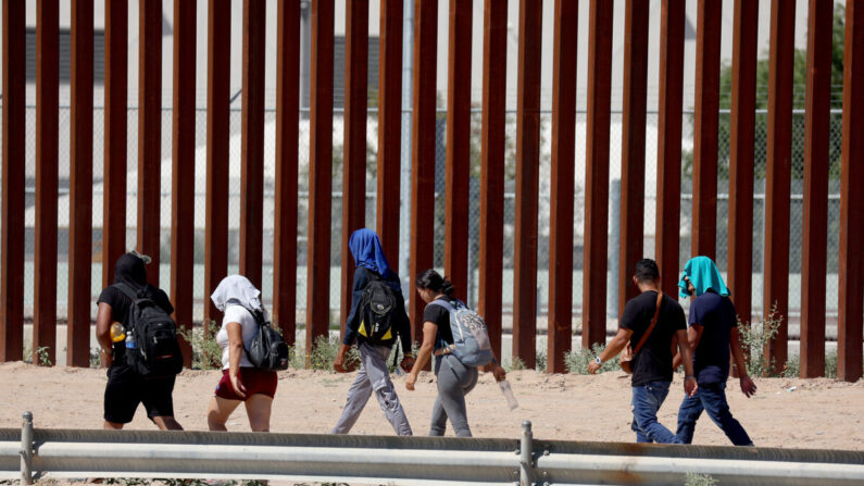 Los migrantes caminan a lo largo de la valla fronteriza de Estados Unidos para entregarse a la Patrulla Fronteriza de Estados Unidos después de cruzar el Río Grande desde México en El Paso, Texas, el 21 de septiembre de 2022. (Joe Raedle/Getty Images)
