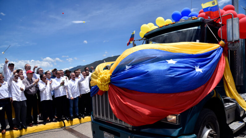 El presidente de Colombia, Gustavo Petro (c), aplaude junto al ministro de Transporte de Venezuela, Ramón Araguayán, mientras un camión de carga venezolano adornado con banderas y globos venezolanos cruza el puente internacional Simón Bolívar durante la reapertura de la frontera comercial entre Venezuela y Colombia el 26 de septiembre de 2022 en Cúcuta, Colombia. (Guillermo Legaria/Getty Images)