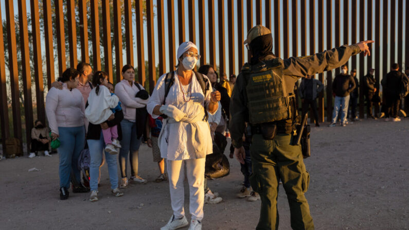 Inmigrantes que buscan asilo en Estados Unidos esperan a ser procesados por agentes de la Patrulla Fronteriza de Estados Unidos después de cruzar a Arizona desde México cerca de Yuma, Arizona, el 26 de septiembre de 2022. (John Moore/Getty Images)
