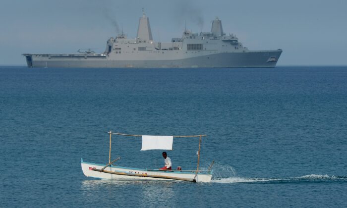 Un pescador filipino en dirección contraria al buque de transporte anfibio USS Green Bay (LPD-20), de la Marina de EE.UU., durante un ejercicio de desembarco anfibio en una playa de San Antonio, en la provincia de Zambales, Filipinas, el 21 de abril de 2015. (TED ALJIBE/AFP/Getty Images)